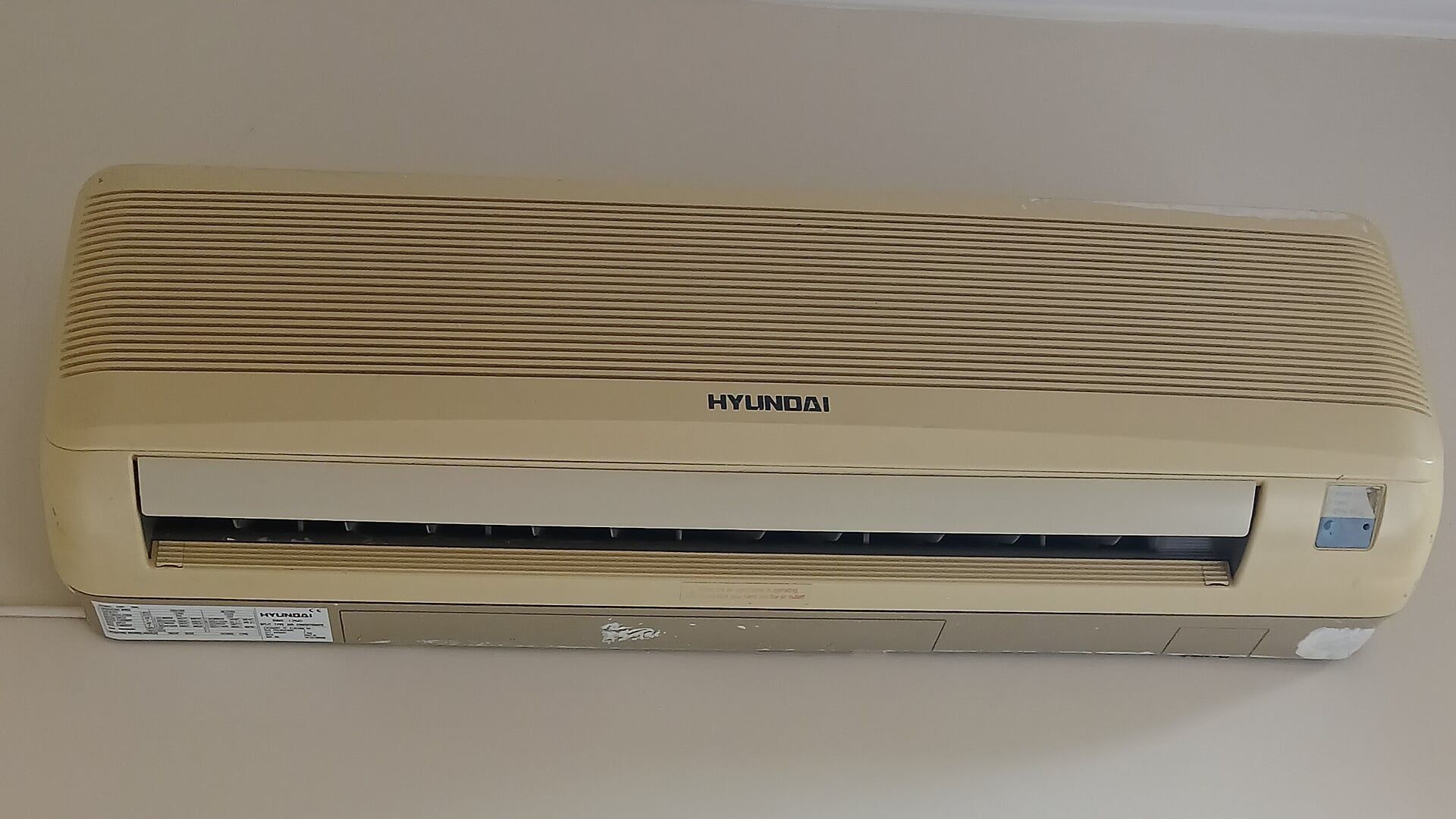 Unidad interior de un aire acondicionado tipo split instalada en la parte alta de una pared.