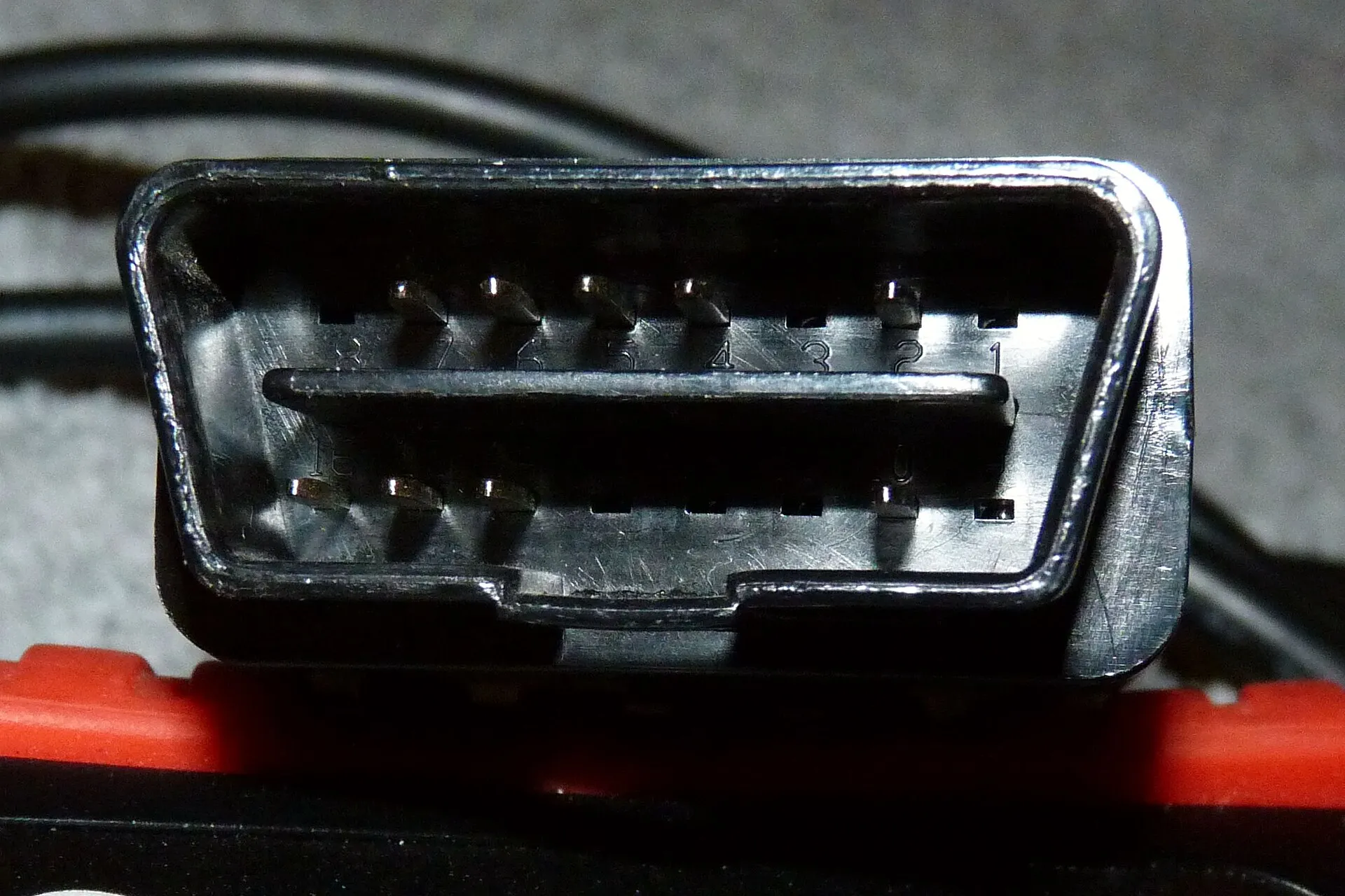 Conector de 16 pines del cable de un escáner OBD-II, el que se enchufa al puerto de diagnóstico del auto.
