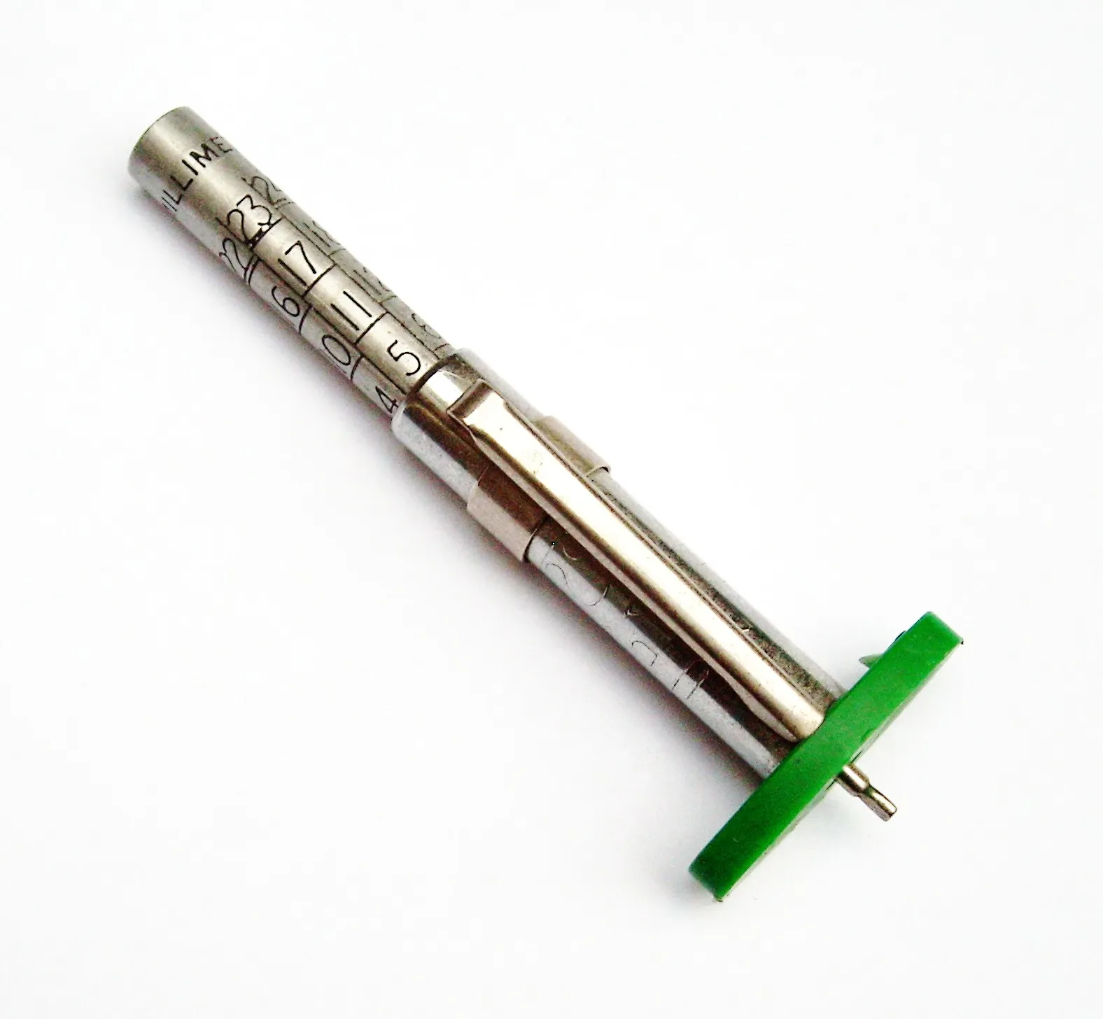 Medidor de profundidad de labrado para llantas, de metal, con escala numerada y base verde.