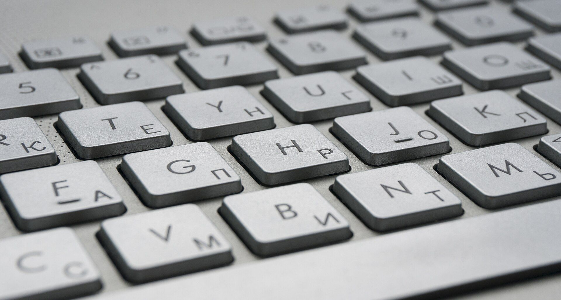 Primer plano de las teclas de un teclado de computadora plateado.